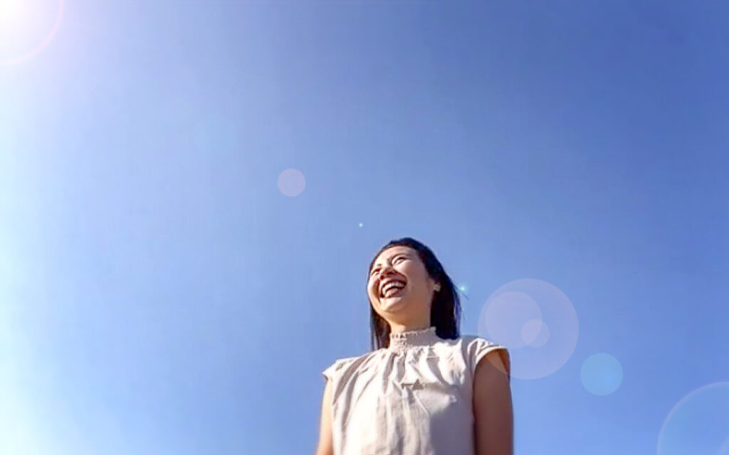 青空と笑顔の女性