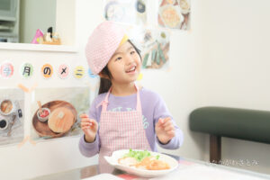 カツレツをお皿に盛り付けることができて笑顔の女の子
