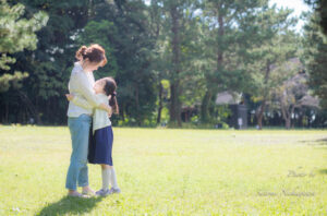 芝生の上で抱き合っている母娘