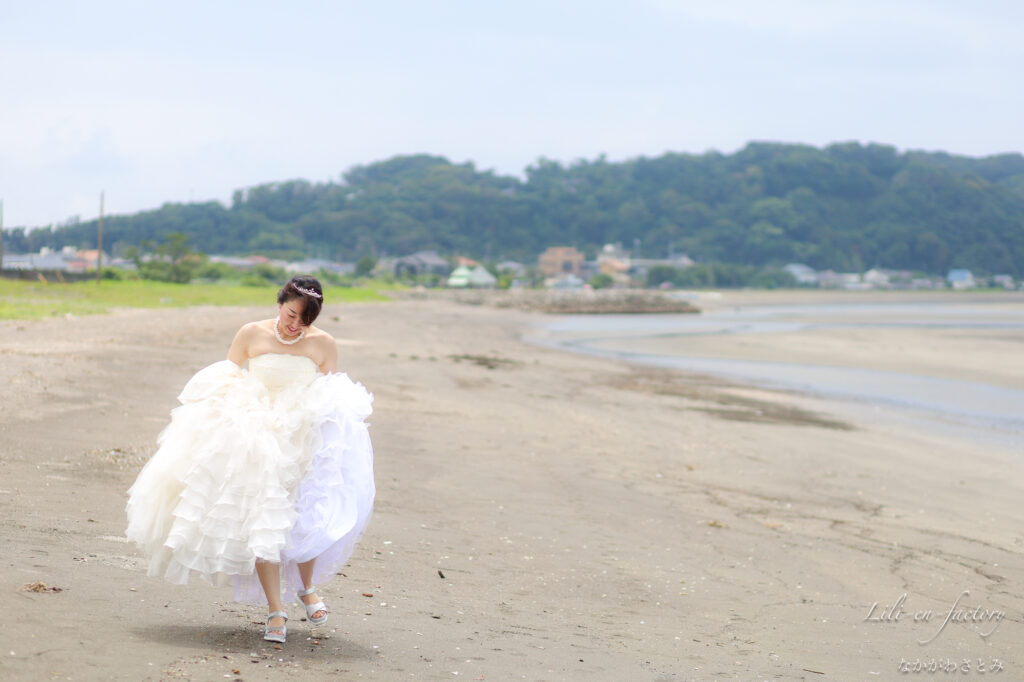 海岸を歩くドレスの女性