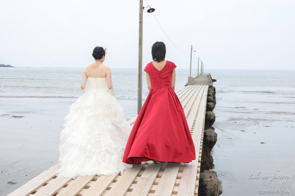 桟橋の上をを歩くドレスの女性