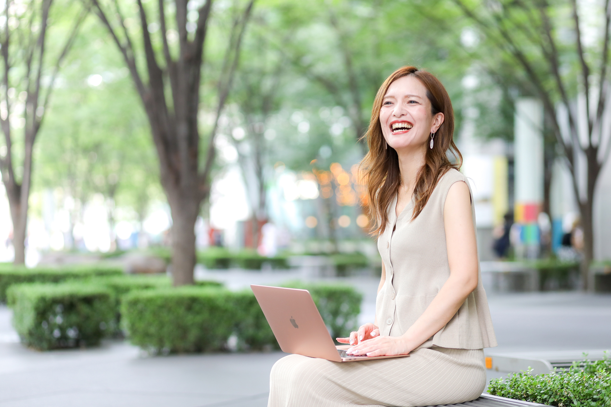 笑顔でノートpcを操作する女性
