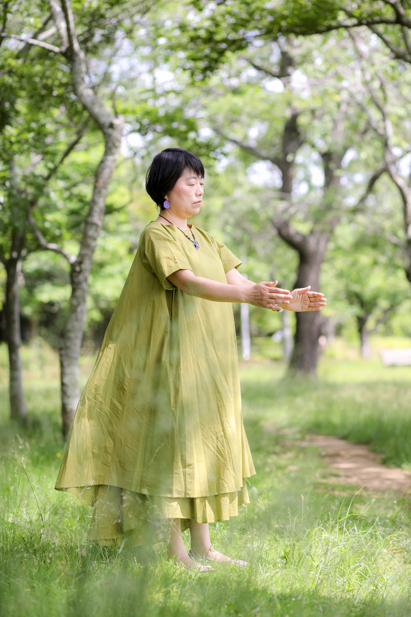 緑の中で気功をする女性