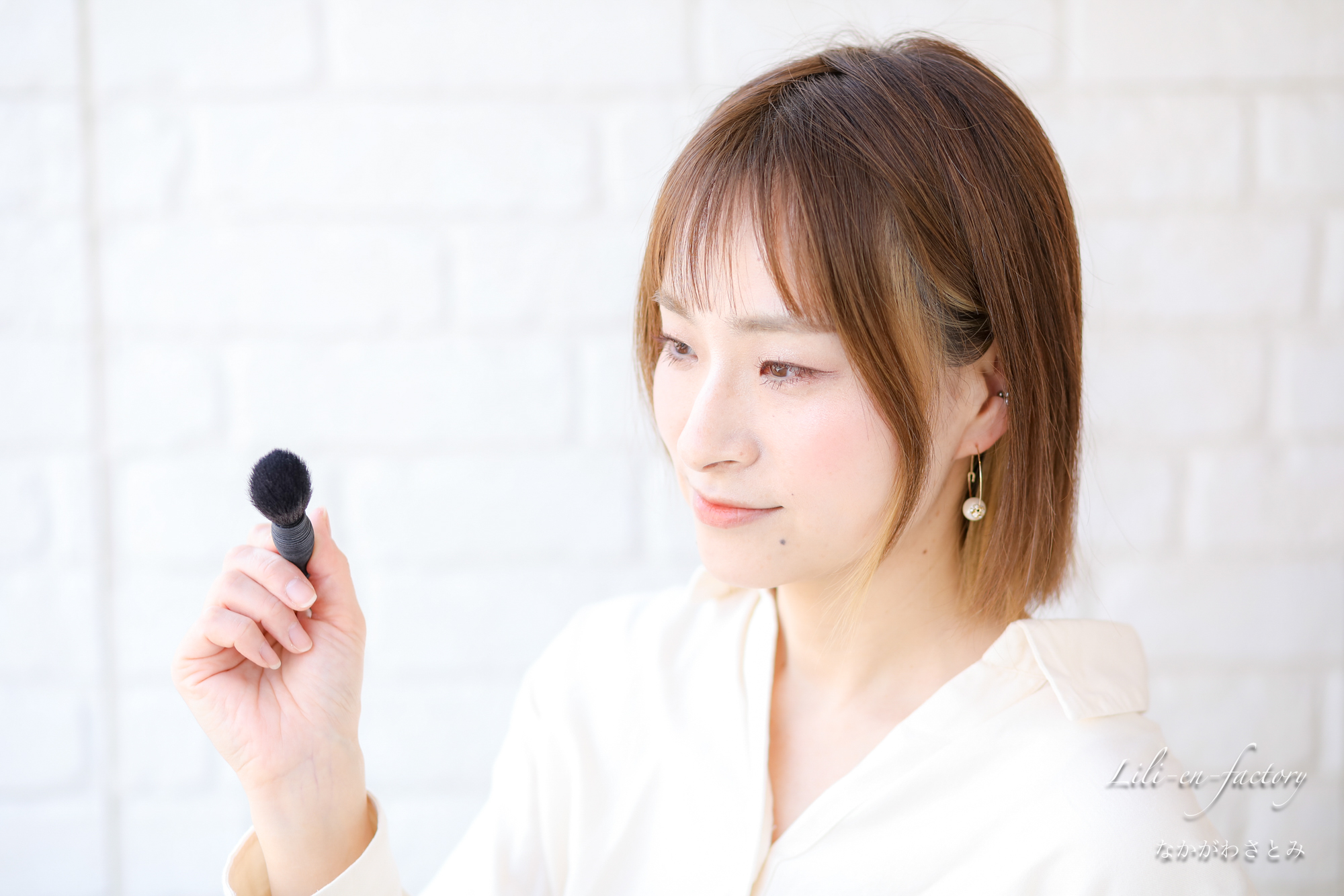 ブラシを持ってメイクするところの女性ヘアメイクさん