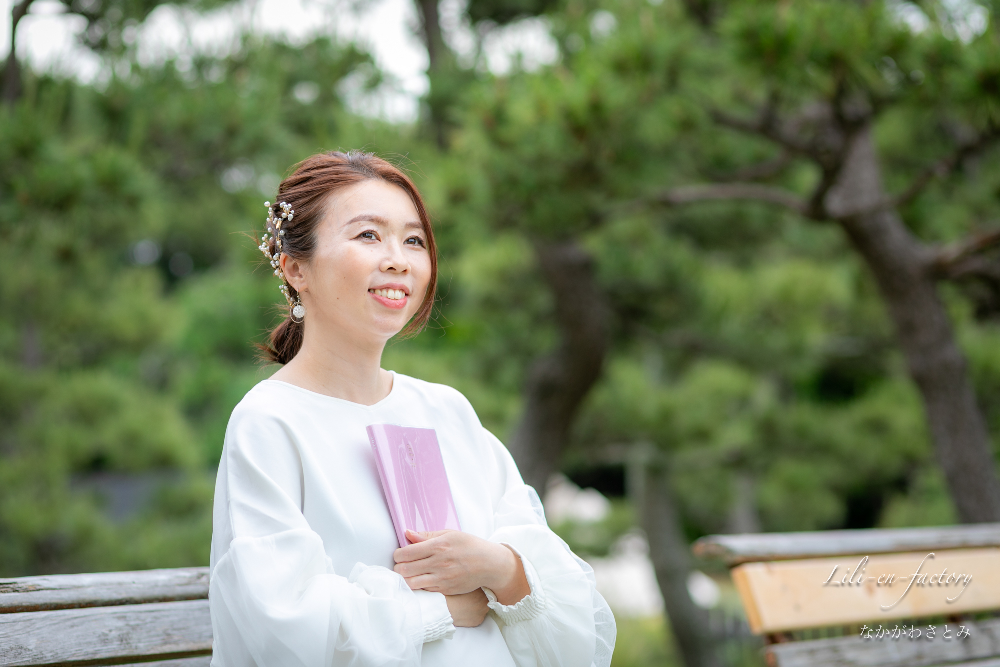 手帳を抱えて座る女性