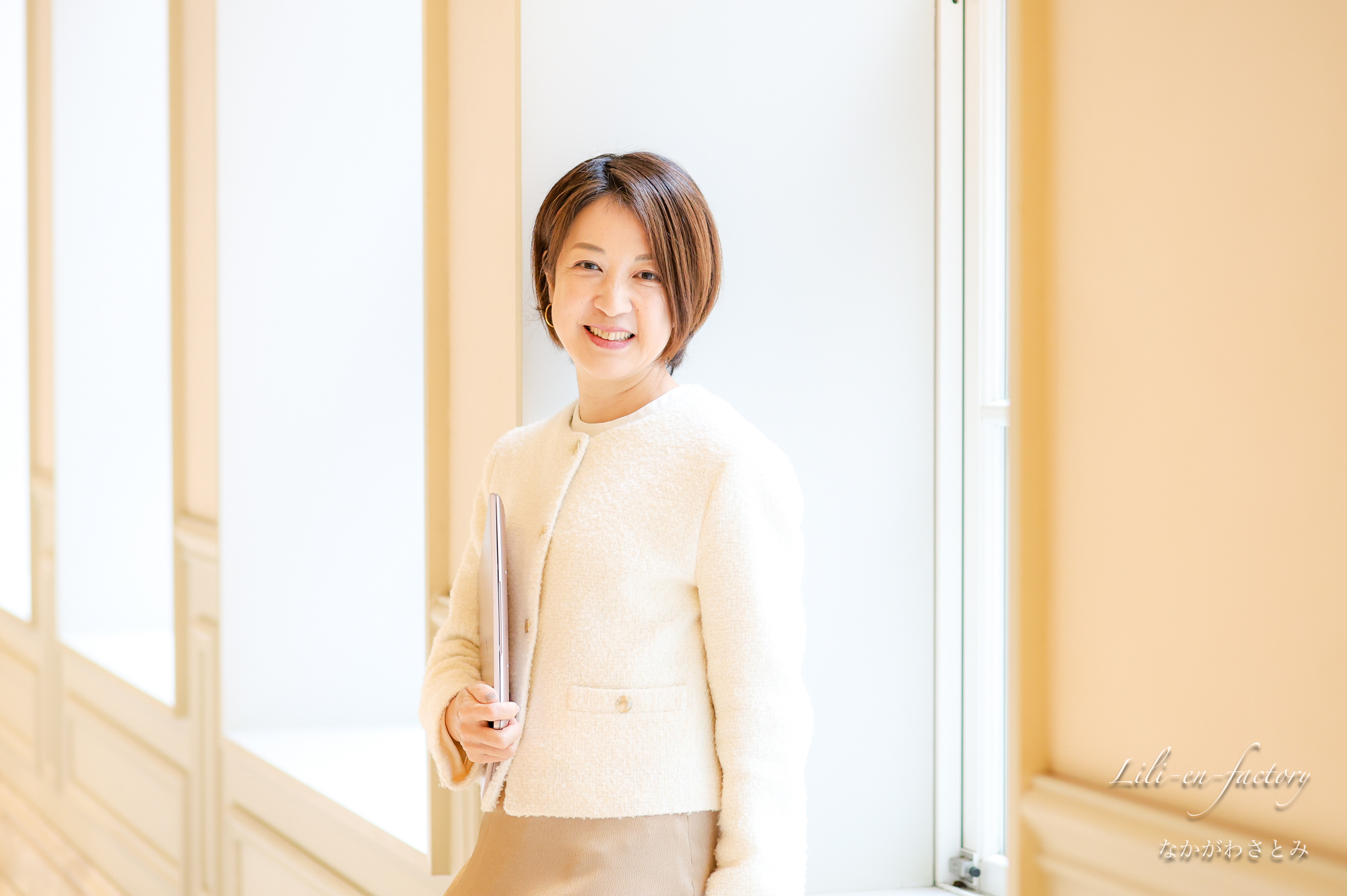 白い服を着て白い壁にもたれている女性