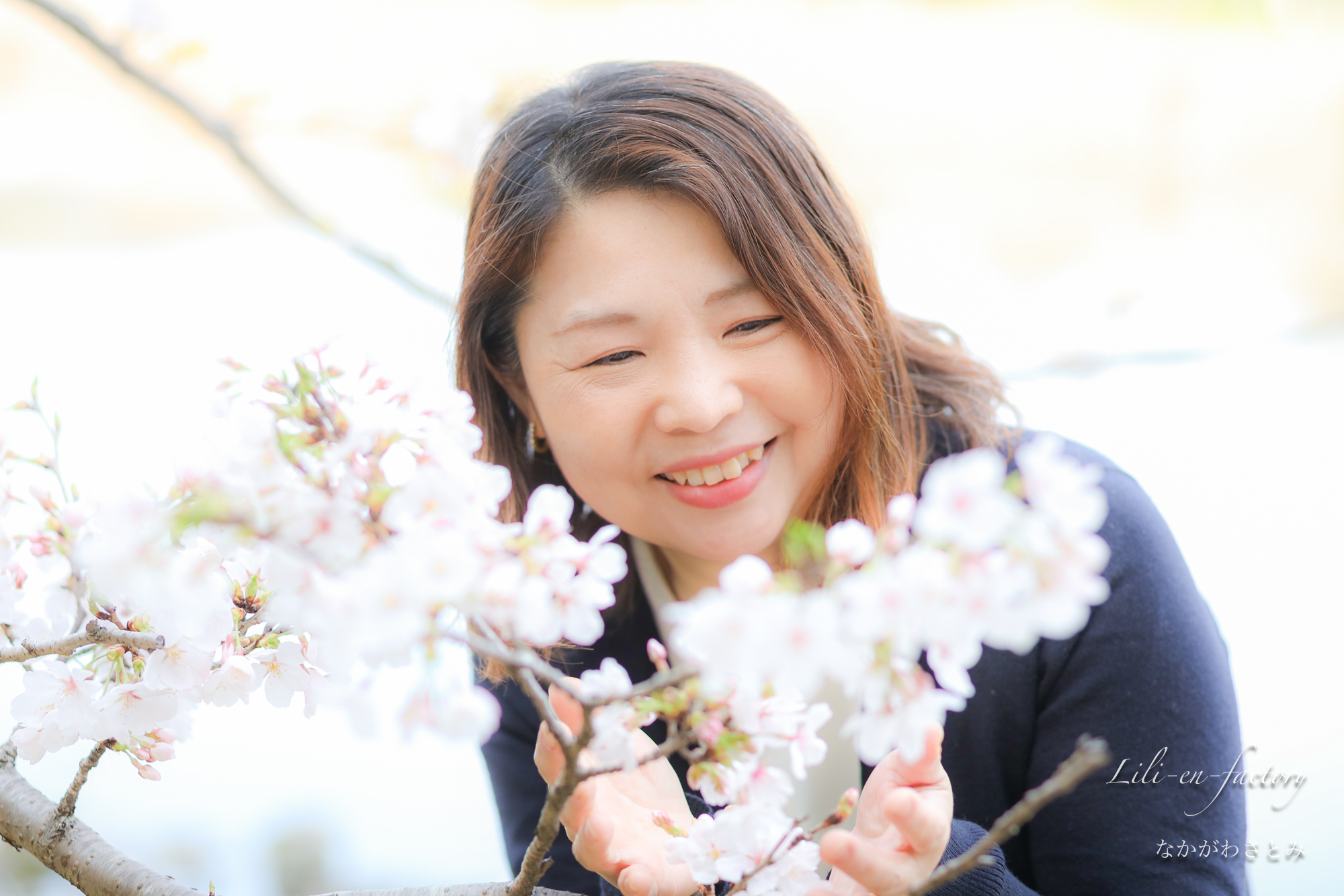 桜と写る笑顔の女性